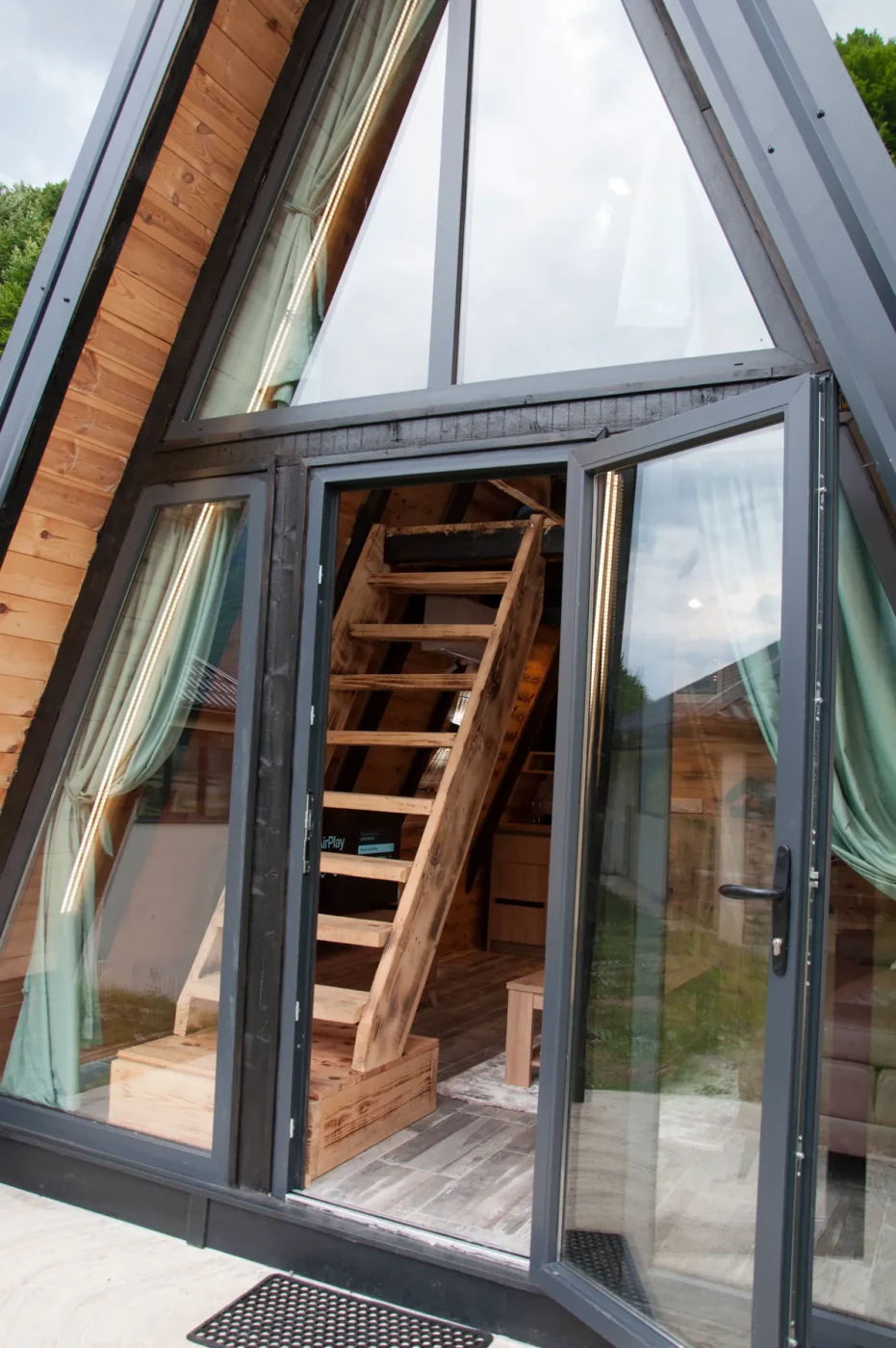 Ulaz u A-frame vikendicu sa drvenim stepenicama
