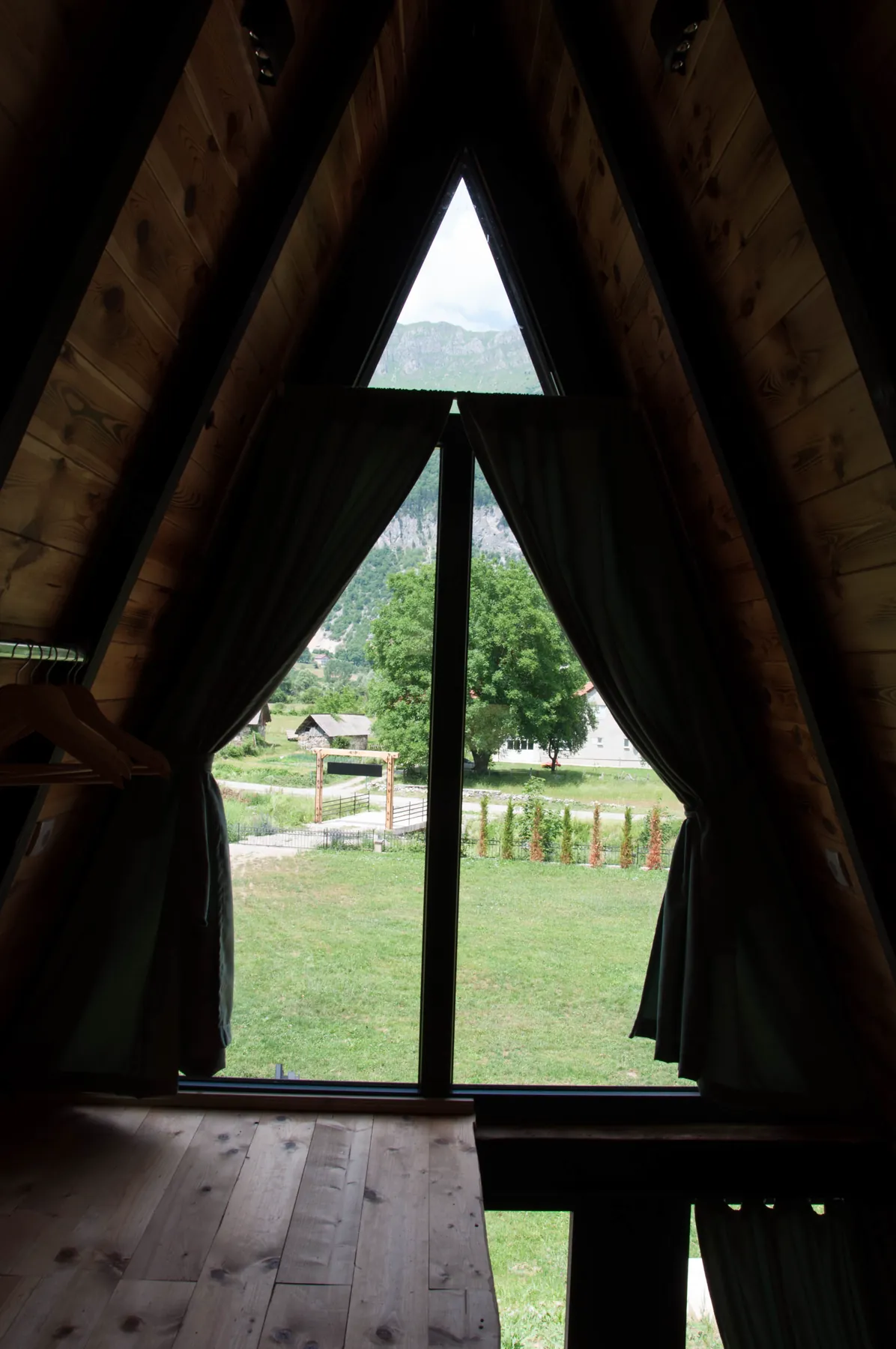 Pogled na planine kroz trouglasti prozor A-frame vikendice